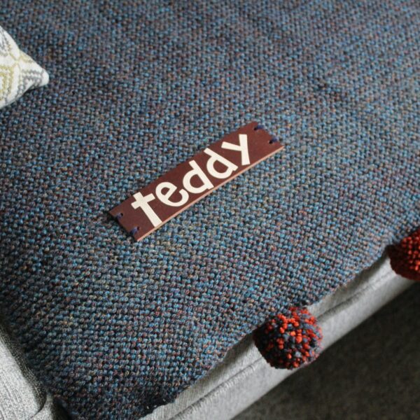 A handcrafted sofa saving pet pad or blanket featuring a thick, high quality personalised leather name tag and optional colour complimenting pompoms!