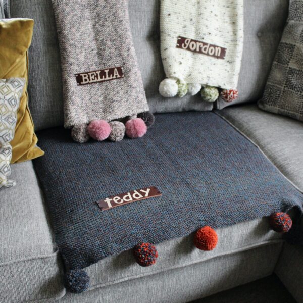 A handcrafted sofa saving pet pad or blanket featuring a thick, high quality personalised leather name tag and optional colour complimenting pompoms!