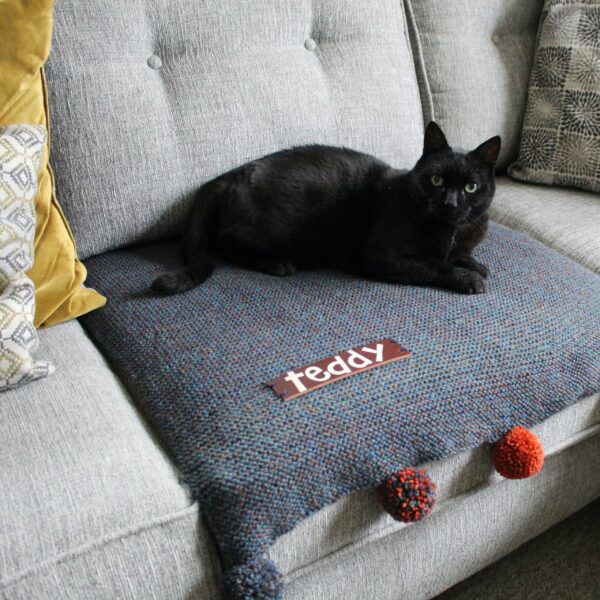 A handcrafted sofa saving pet pad or blanket featuring a thick, high quality personalised leather name tag and optional colour complimenting pompoms!