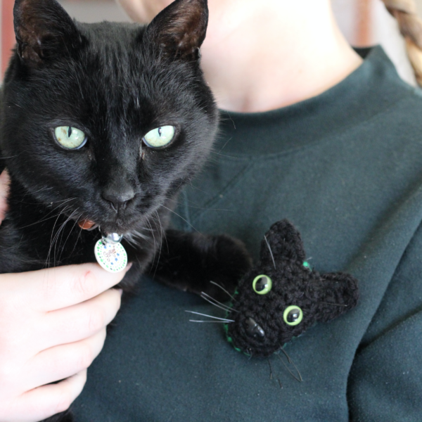 A personalised crocheted brooch with the face of your cat, created from your photographs and lovingly attached to a secure closing brooch pin.