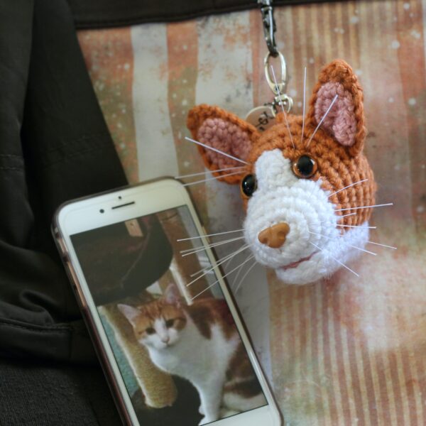 A personalised crochet soft toy head of your cat created from photographs of your furry companion, lovingly attached to a hanging silver lobster clasp.