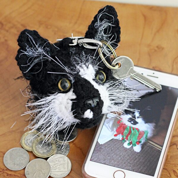 A personalised crochet soft toy head of your cat created from photographs of your furry companion, lovingly attached to a hanging silver lobster clasp.