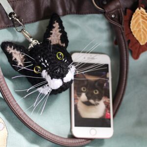 A personalised crochet soft toy head of your cat created from photographs of your furry companion, lovingly attached to a hanging silver lobster clasp.