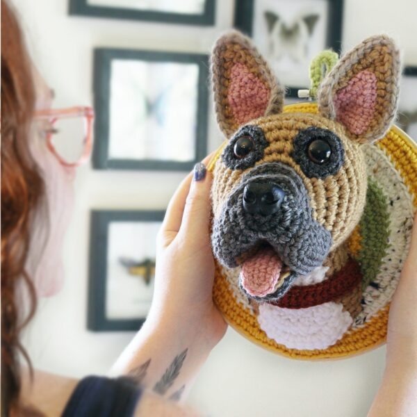 A bespoke and handcrafted crochet soft toy head created from photographs of your furry companion, lovingly mounted on a hanging embroidery hoop.